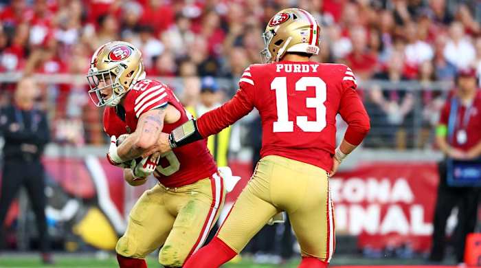 Brock Purdy hands the ball off to Christian McCaffrey against the Cardinals.